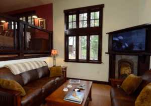 living area with leather couches, fireplace, and television