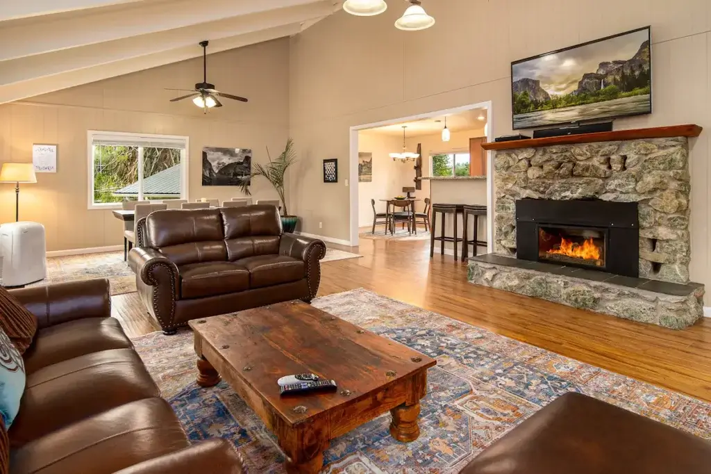 living room with stone fireplace and leather couches