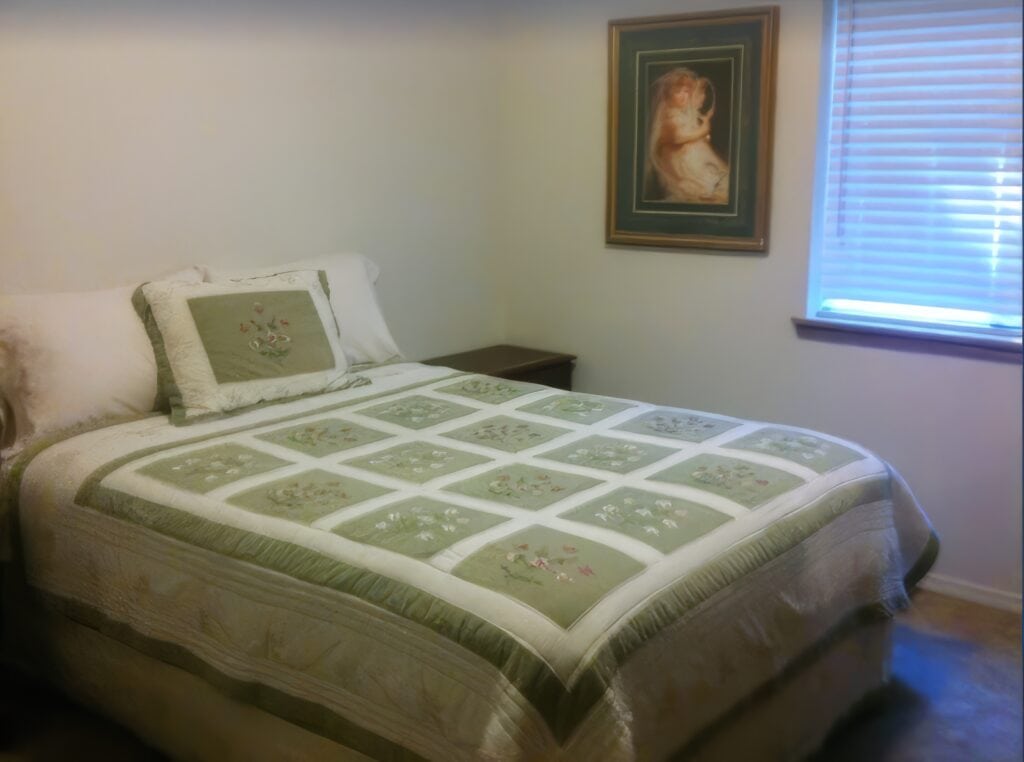 bedroom with quilted bedspread and queen bed