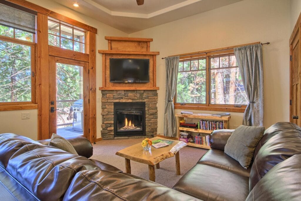 living room with stone fireplace and television