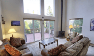 living room with tall windows and wood stove