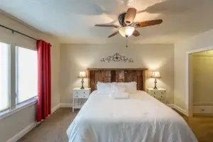 bedroom with large bed, ceiling fan and window