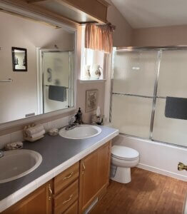bathroom with walk in shower and his and hers sinks