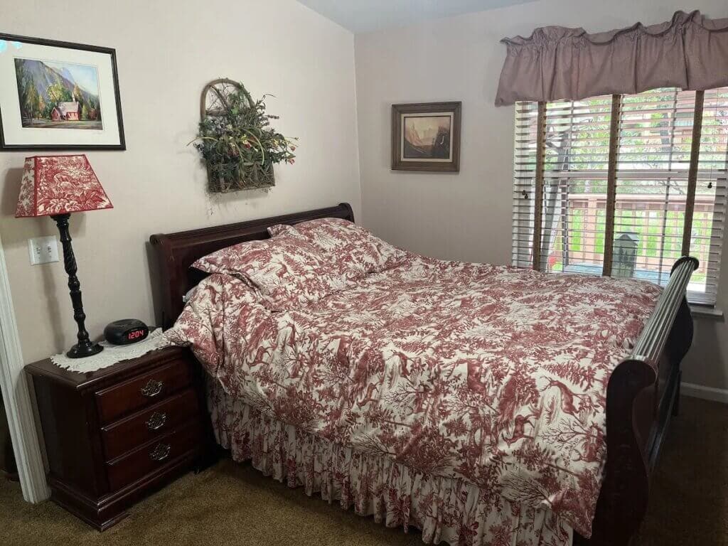 bedroom with pattered bed spread and balcony access