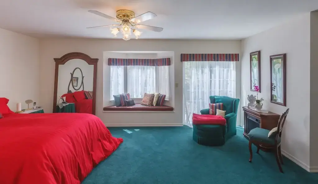 bedroom with teal carpet and red accents