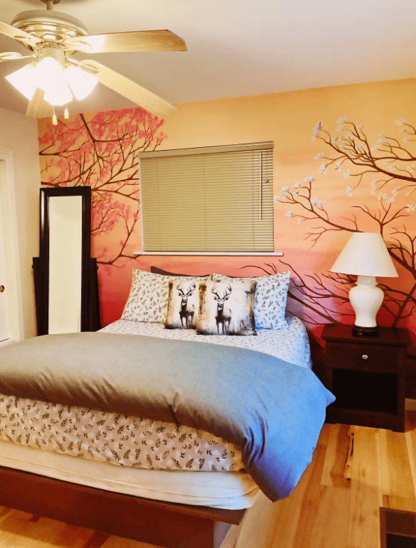 bedroom with queen bed and mural