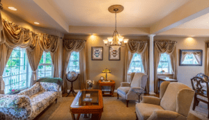 formal living room with drapes, victorian couches and chairs