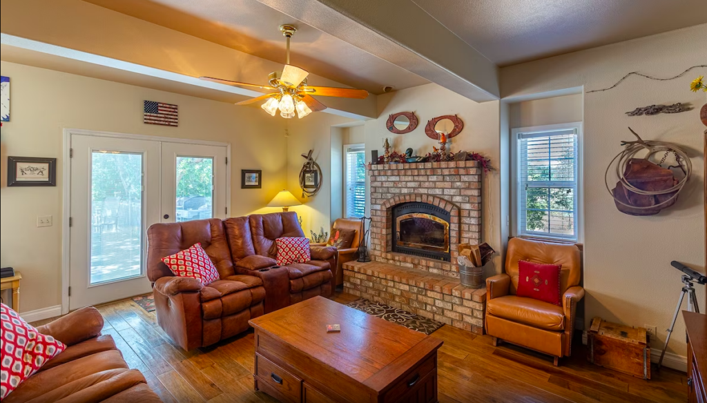 living room with couches and stone fireplace and beams