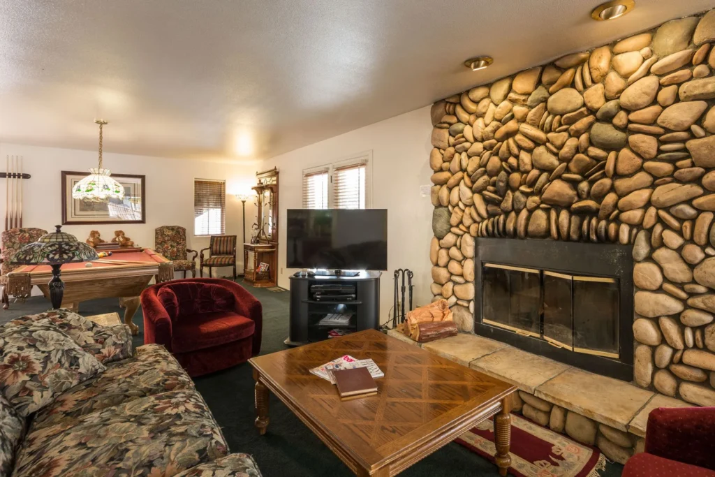 living room with seating , television and stone fireplace