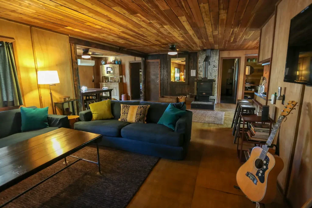 Living room with wood stove, couches and wood paneling