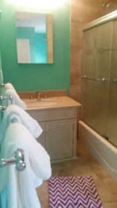 bathroom with shower tub and green walls