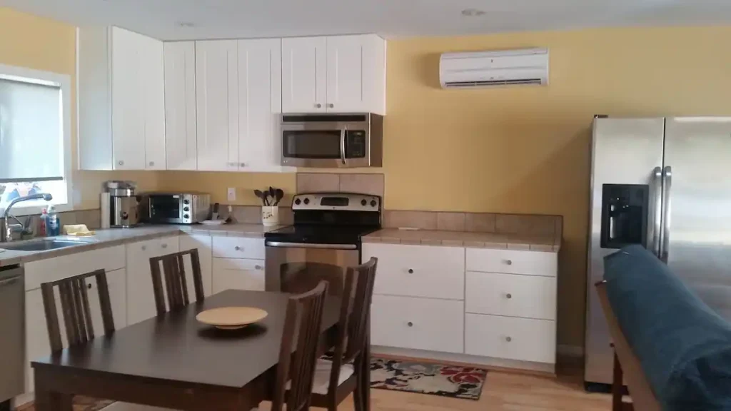 kitchen area with white cabinets and dining table