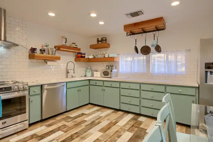 green kitchen cabinets with floating shelves
