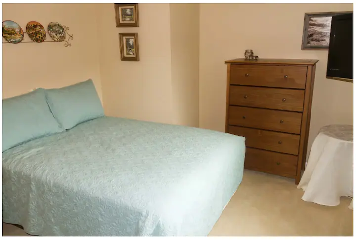 bedroom with blue bedspread and dresser