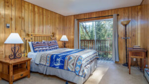 bedroom with blue bedding and balcony