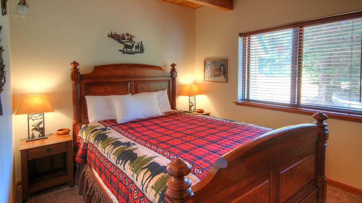 bedroom with plaid bedding and beamed ceiling