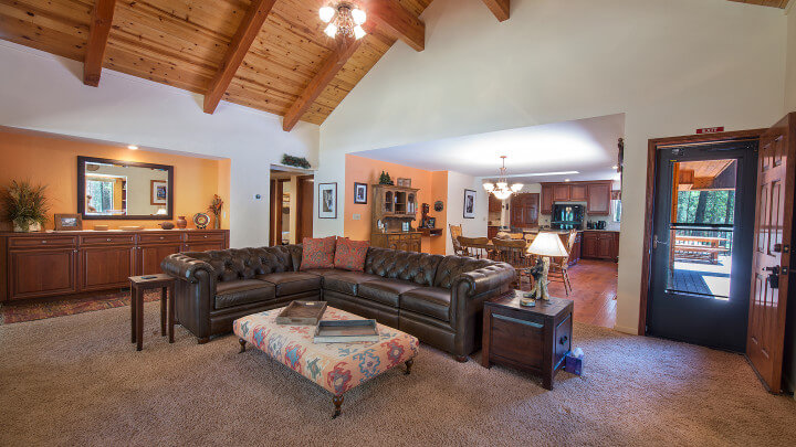 living room with leather couches and high wood ceiling