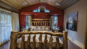 bedroom with hand carded wood bed frame and wooden ceiling
