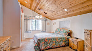 bedroom with queen bed and wood planked ceiling