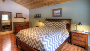 bedroom with wood ceiling and chevron bedding