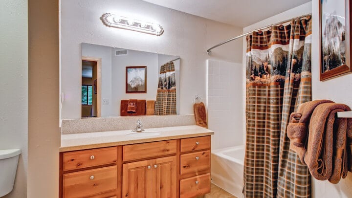 bathroom with tub shower and wood vanity
