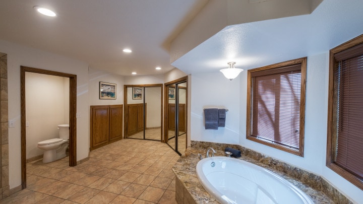 bathroom with Jacuzzi tub and mirrored closet