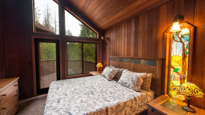 bedroom with vaulted ceilings and large windows