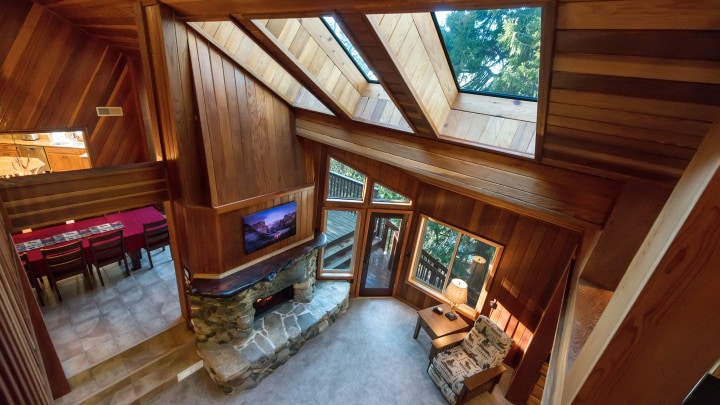 loft view of living room with fireplace and skylights