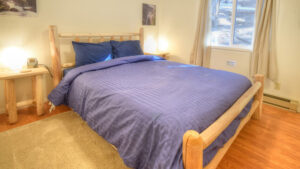 bedroom with blue bedding and wood carved bed frame