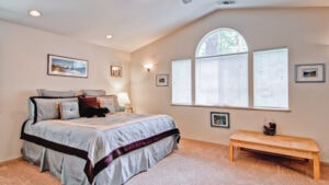 main bedroom with arched window and queen bed