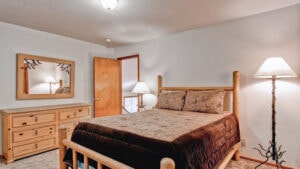 bedroom with queen bed and carved wood bedframe