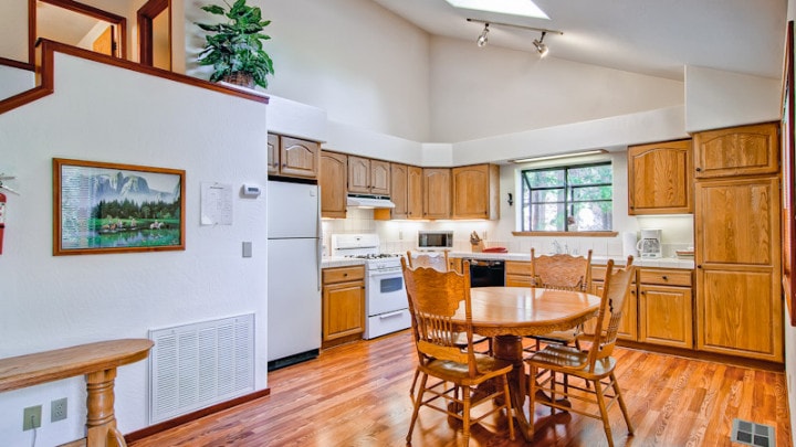 kitchen with tall ceilings wood cabinets and dining area