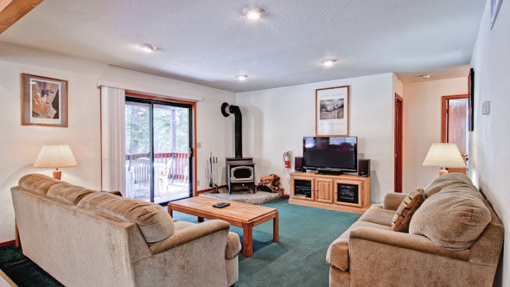 living room with wood stove, television and couches