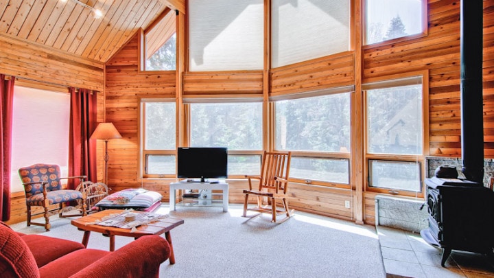 living room with large windows and wood stove