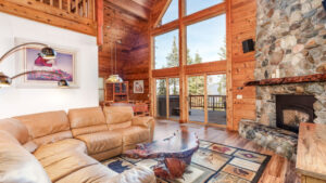 living room with vaulted ceiling and stone fireplace