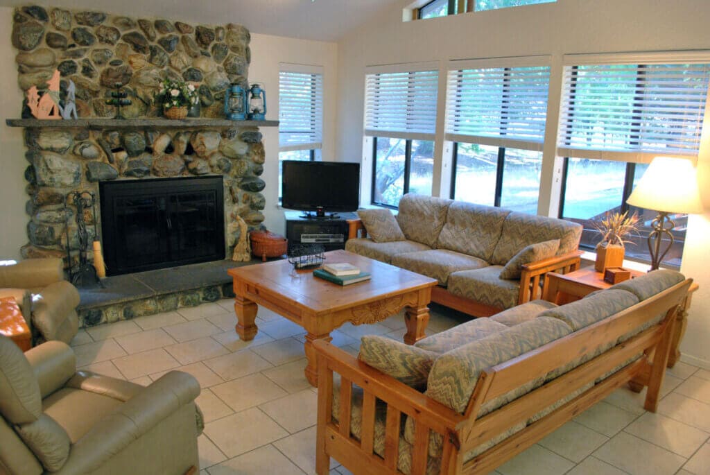 living room with couches, TV, and stone fireplace