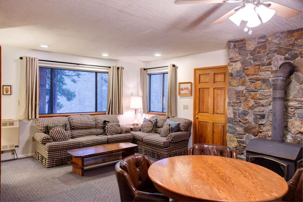 living room with couches, table, and wood stove