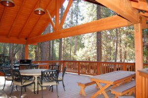 deck with a frame covering, outdoor seating and dining with grill