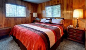 bedroom with queen bed and wood paneled walls