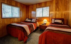 bedroom with two twin beds and wood paneled walls