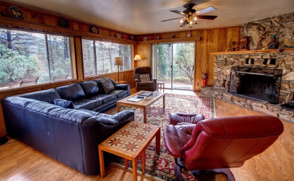 living room with couch and seating, stone fireplace