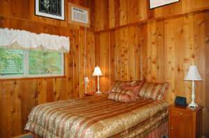 bedroom with full bed and wood paneling