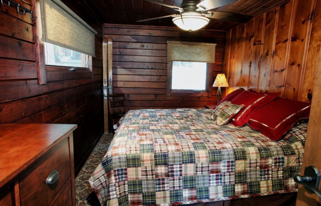 bedroom with wood walls and queen bed