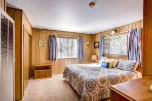 bedroom with queen bed and wood paneled wall
