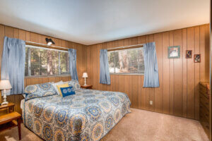bedroom with queen bed and wood paneled walls