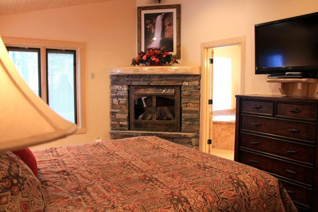 bedroom with television and fireplace