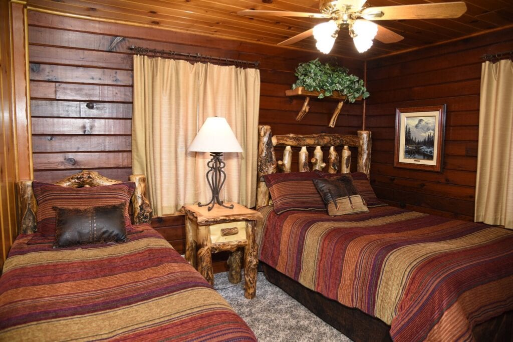 bedroom with two twin bed frames and wood paneled walls