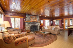 living room with couches and chairs and stone fireplace