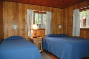 bedroom with two beds with blue bedding and a window