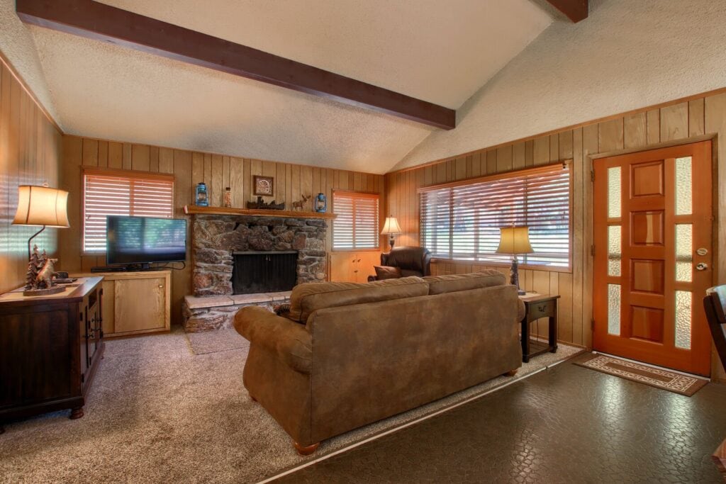 living room with beams, stone fireplace and couch